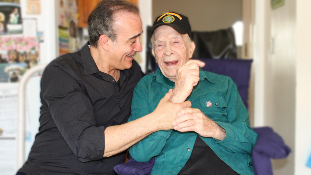 Man and male hospice resident laughing together