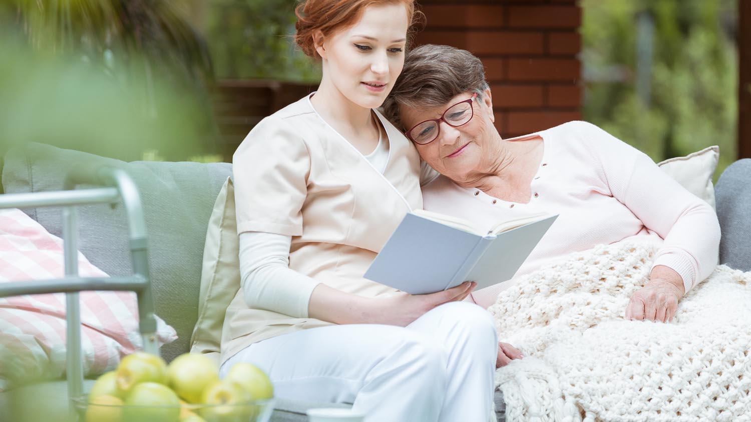 Nurse reading to female hospice patient